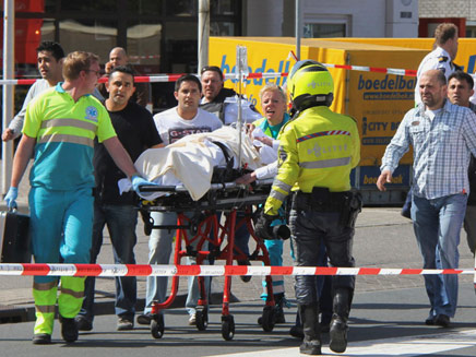 מפנים גופות מזירת הירי, היום בהולנד (צילום: AP)
