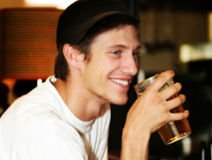 גבר שותה בירה ומחייך (צילום: istockphoto)