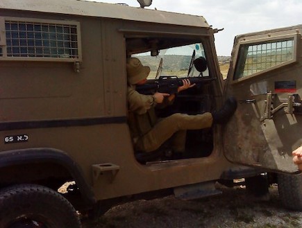 חייל מילואים יושב בג'יפ מכוון נשק (צילום: מיכאל גרשקוביץ)