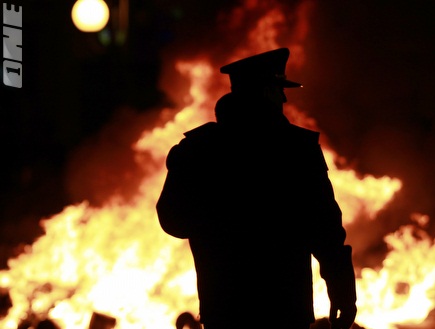 שוטר מתבונן באש שהבעירו האוהדים (רויטרס) (צילום: מערכת ONE)