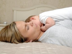 אישה עם תינוק בן יומו שוכבת במיטה (צילום: Lisa Valder, Istock)