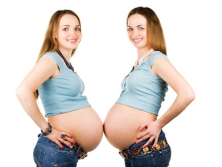 אחיות תאומות בהריון עומדות בטן מול בטן (צילום: Kirill Zdorov, Istock)