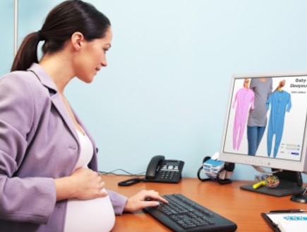 אישה בהריון במשרד מקלידה ומסתכלת במסך המחשב (צילום: istockphoto)