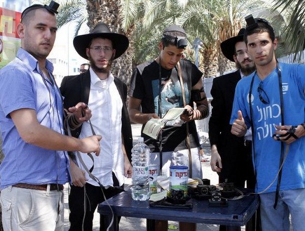 אוהדים ישראליים מניחים תפילין לפני המשחק (יוסי ציפקיס) (צילום: מערכת ONE)
