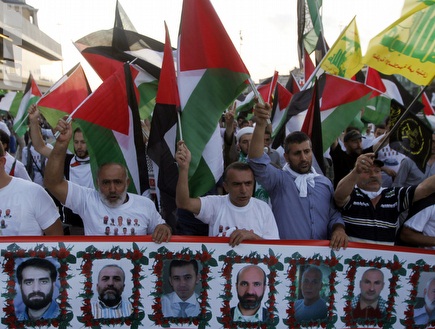 מפגינים פרו פלסטינים עם תמונות של הרוגי המרמרה לפני המשחק (רויטרס) (צילום: מערכת ONE)