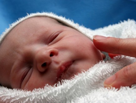 אצבעות מונחות על תינוק בן יומו (צילום: AngelIce, Istock)
