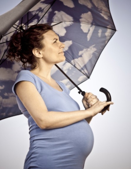 אישה בהריון עם מטריה (צילום: Factoria Singular, Istock)