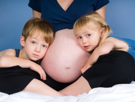 אישה בהריון עם שני ילדים גדולים (צילום: YanC, Istock)
