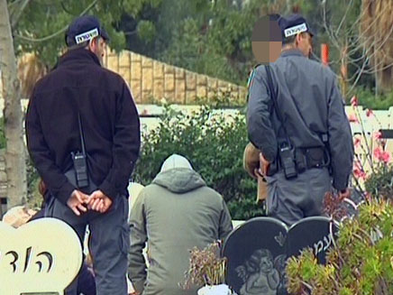 שוטרים לצד ההורים על קבר הבן (צילום: חדשות 2)