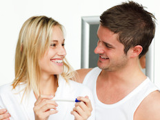 זוג מחייך עם בדיקת הריון (צילום: אימג'בנק / Thinkstock)
