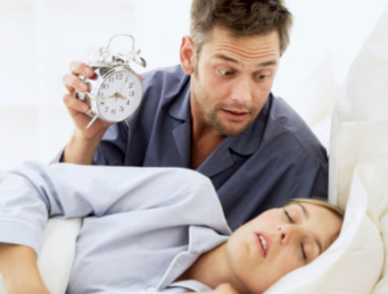 זוג במיטה, האישה ישנה הגבר מסתכל בשעון (צילום: אימג'בנק / Thinkstock)