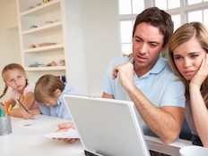 זו הורים מסתכל על חשבונות עם ילדים ברקע (צילום: אימג'בנק / Thinkstock)