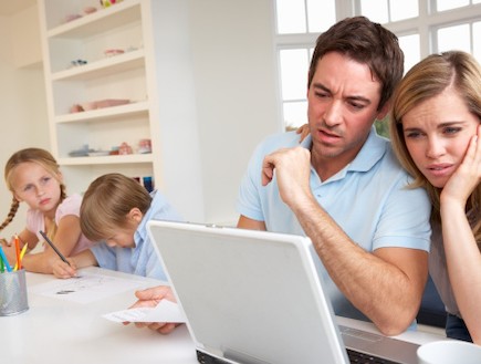 זו הורים מסתכל על חשבונות עם ילדים ברקע (צילום: אימג'בנק / Thinkstock)