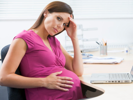 אישה בהריון מול מחשב מחזיקה את ראשה (צילום: אימג'בנק / Thinkstock)