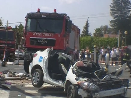 הכבאית והרכב המרוסק בזירת התאונה (צילום: חדשות 2)