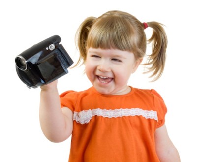 ילדה מחזיקה מצלמת וידאו ומחייכת (צילום: אימג'בנק / Thinkstock)
