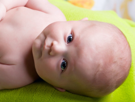 תינוק שוכב על סדין ירוק (צילום: אימג'בנק / Thinkstock)