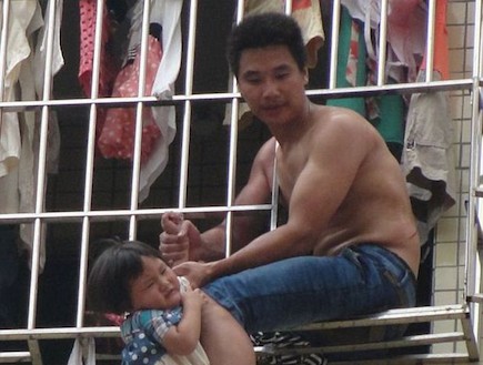 סיני מטלטל את בתו מהחלון (צילום: dailymail.co.uk)
