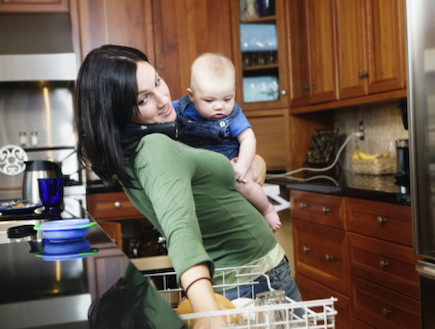 אמא מחזיקה תינוק ומסדרת כלים במדיח (צילום: אימג'בנק / Thinkstock)