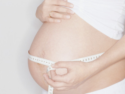 אישה בהריון מודדת את הבטן עם סרט מדידה (צילום: אימג'בנק / Thinkstock)