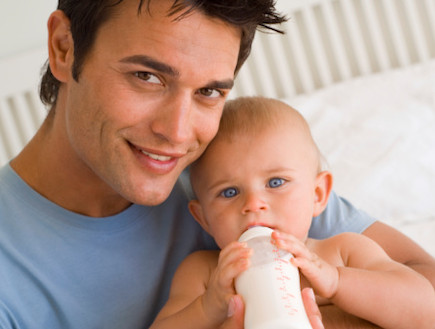 גבר מאכיל תינוק בבקבוק