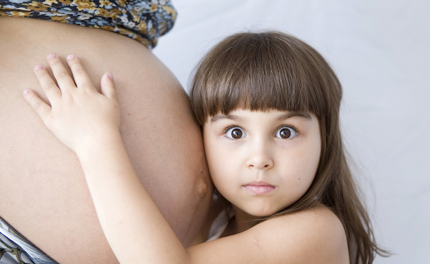 ילדה מחבקת את בטן אמה ההריונית (צילום: אימג'בנק / Thinkstock)