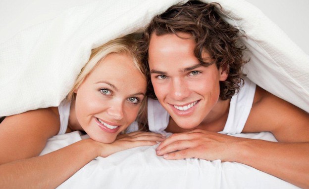 גבר ואישה שוכבים על הבטן במיטה תחת שמיכה (צילום: אימג'בנק / Thinkstock)