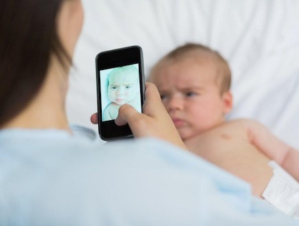 אמא מצלמת תינוק באייפון (צילום: אימג'בנק / Thinkstock)