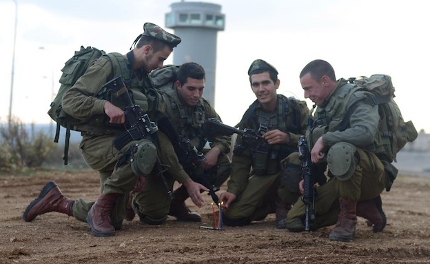 חיילים מדליקים חנוכיה (צילום: יעל שלח, עיתון "במחנה")
