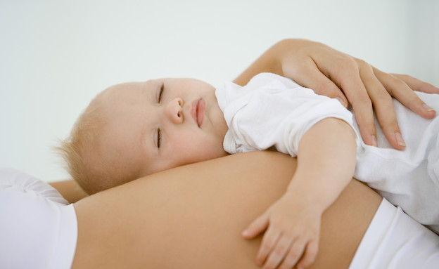 תינוק ישן על בטן הריונית (צילום: אימג'בנק / Thinkstock)
