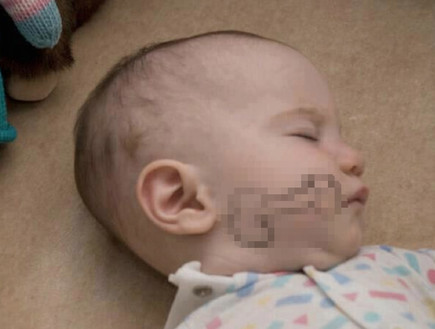תמונה של תינוק עם איבר מין מצויר על הלחי
