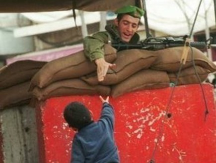 חייל מושיט יד לילד פלסטיני