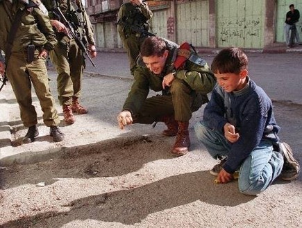 חייל משחק עם ילד פלסטיני