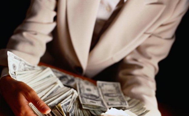 אישה בחליפה גורפת כסף (צילום: אימג'בנק / Thinkstock)