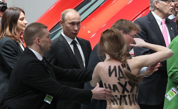 פוטין ומפגינה חשופת חזה (צילום: Sasha Mordovets, GettyImages IL)