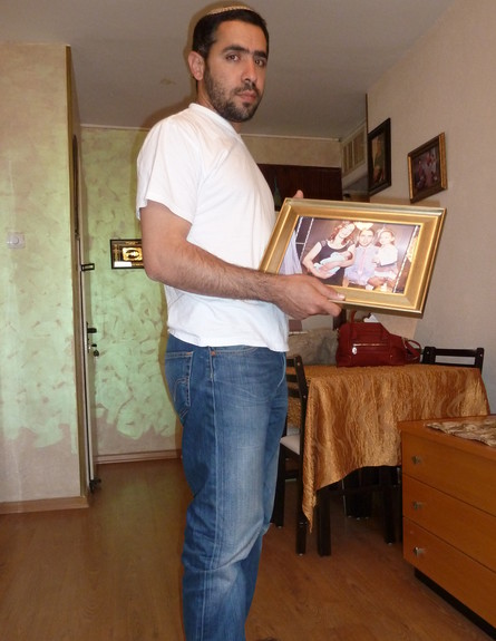 ערן בר מוחה מחזיק את תמונת המשפחה (צילום: שמעון אפרגן)