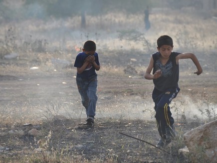 ילדים בורחים מגז מדמיע בכפר בודרוס (צילום: אפרת לכטר)