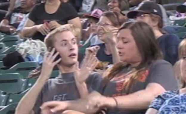 בחורה מתעצבנת על בחור במשחק בייסבול