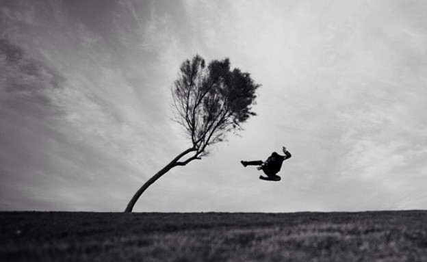 תורג'י מצלם את עצמו קופץ על עץ בשדה נטוש (צילום: איתי תורג'מן)