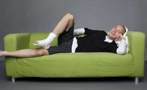 איש שוכב על ספה עם רגל שבורה (צילום: אימג'בנק / Thinkstock)