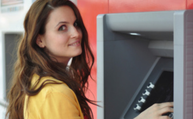 צעירה מושכת כסף בכספומט