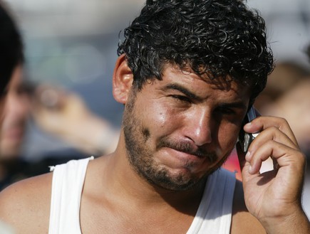 פליט סורי מדבר בטלפון