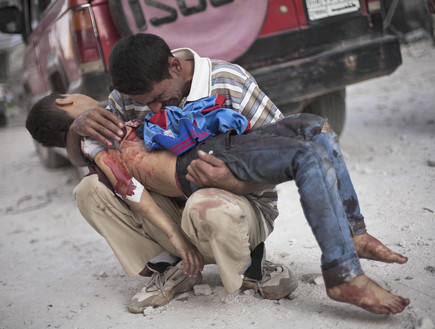 ילד מחזיק ילד הרוג בסוריה (צילום: AP Photos/ Manu Brabo)