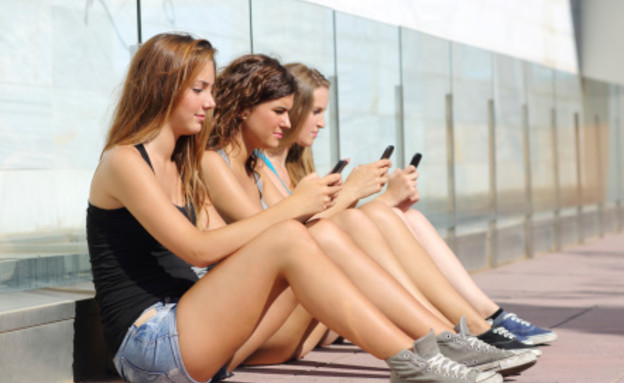 צעירים מחזיקים טלפון (צילום: אימג'בנק / Thinkstock)