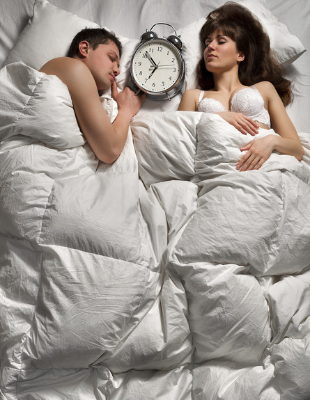זוג במיטה עם שעון (צילום: Thinkstock)