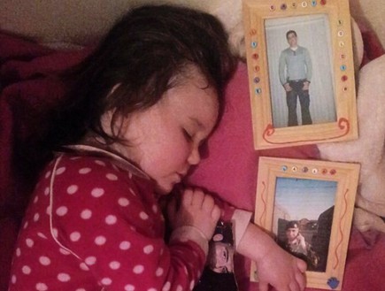 ילדה ישנה עם תמונות של אביה החייל (צילום: rossparry)