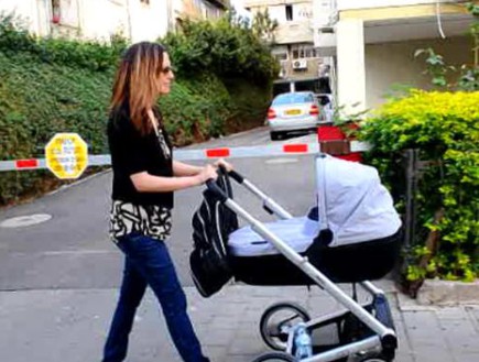 יונית לוי מטיילת עם התינוק (תמונת AVI: צילום מסך)