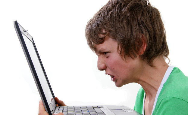 צעיר צועק על המחשב (צילום: אימג'בנק / Thinkstock)