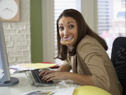 אישה מג'נגלת - עובדת על המחשב ואוכלת סופגניה (צילום: Fuse, Thinkstock)