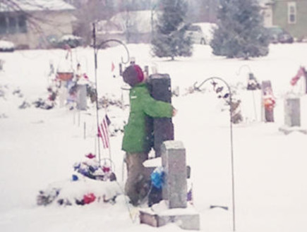 ילד מחבק את קבר אביו (צילום: טיפאני אקרט)